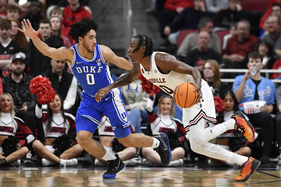 Louisville guard Mike James (0), right, attempts to drive past Duke guard Jared McCain (0) during the first half of an NCAA college basketball game in Louisville, Ky., Tuesday, Jan. 23, 2024. (AP Photo/Timothy D. Easley)