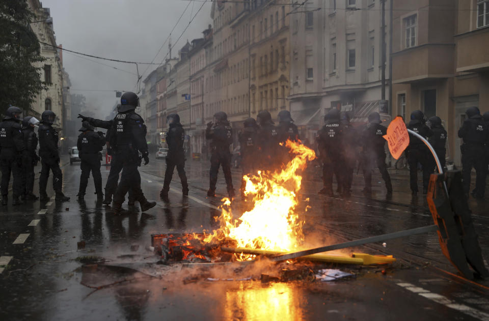 Police officers secure Wolfgang-Heinze-Strasse after riots broke out at the end of a left-wing demonstration, in Leipzig, Germany, Saturday, Sept. 18, 2021. The campaign alliance "We are all Linx" had mobilized nationwide for the demonstration. (Jan Woitas/dpa via AP)