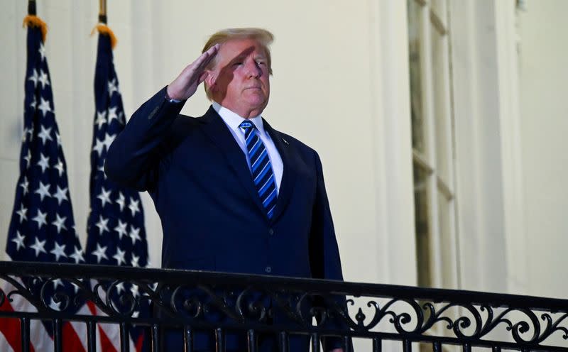 FILE PHOTO: U.S. President Donald Trump poses without face mask as he returns to the White House after being hospitalized at Walter Reed Medical Center for coronavirus disease (COVID-19), in Washington