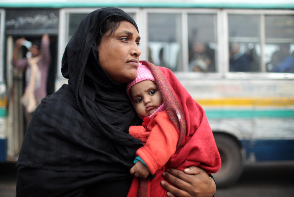 A woman waits at a bus station with her child during a 48-hour nationwide strike called by the main opposition Bangladesh Nationalist Party (BNP) against Sunday's general election, in Dhaka, Bangladesh, Monday, Jan. 6, 2014. Bangladesh's ruling Awami League won one of the most violent elections in the country's history, marred by street fighting, low turnout and a boycott by the opposition that made the results a foregone conclusion. (AP Photo/A.M. Ahad)