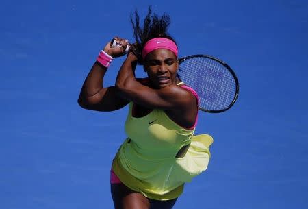 Serena Williams of the U.S. hits a return to Garbine Muguruza of Spain during their women's singles fourth round match at the Australian Open 2015 tennis tournament in Melbourne January 26, 2015. REUTERS/Carlos Barria