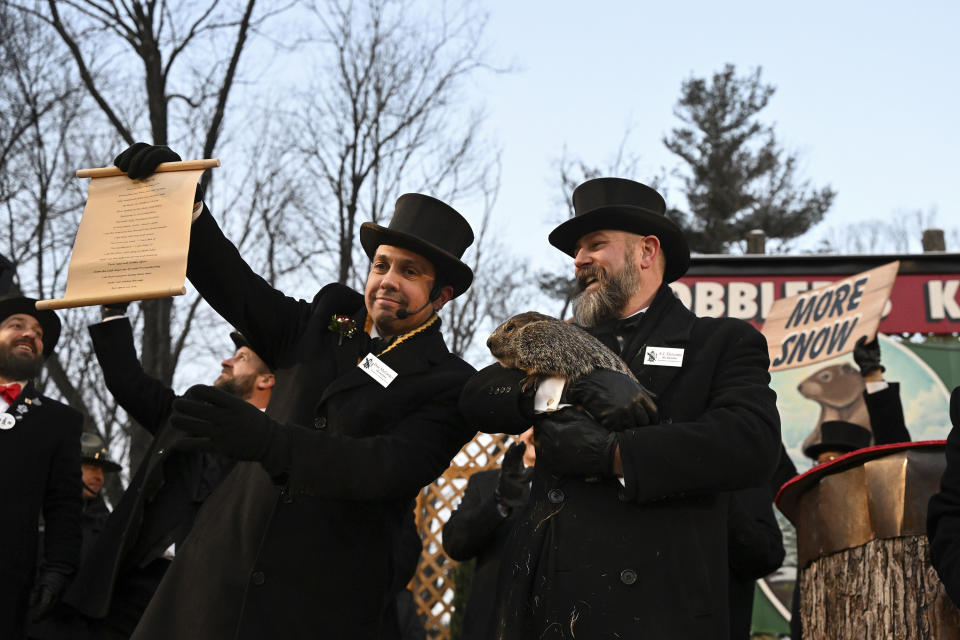 FILE - Groundhog Club handler A.J. Dereume holds Punxsutawney Phil, the weather prognosticating groundhog, while Vice President Dan McGinley reads the scroll during the 137th celebration of Groundhog Day on Gobbler's Knob in Punxsutawney, Pa., Feb. 2, 2023. The arrival of annual Groundhog Day celebrations Friday, Feb. 2, 2024, will draw thousands of people to see celebrity woodchuck Phil at Gobbler's Knob in Punxsutawney, Pa. — an event that exploded in popularity after the 1993 Bill Murray movie. (AP Photo/Barry Reeger, File)