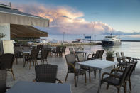 Cafes and restaurants are empty in the harbor in Fazana, Croatia, Tuesday, May 26, 2020. As local businesses suffered under the coronavirus lockdown, even once well-off families have found themselves struggling and many have turned to the local "Our Dream Their Smile" group for help with food, other necessities or legal advice. (AP Photo/Darko Bandic)