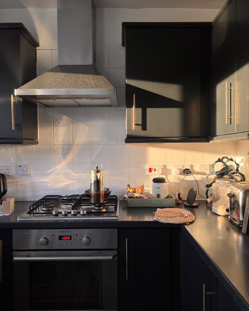 White kitchen with black cabinets and white tile backsplash after remodel