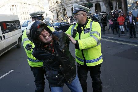 A man is detained by police officers during a protest by London cab drivers against Uber in central London, Britain February 10, 2016. REUTERS/Stefan Wermuth