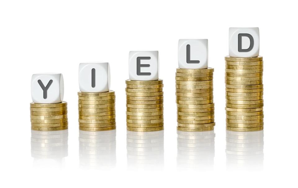 Stacks of coins with blocks on top of them spelling the word Yield.