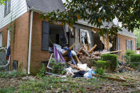 Debris surrounds a home, Tuesday, April 30, 2024, where a shootout between a suspect and officers occurred on Monday, in Charlotte, N.C. Police say a shootout that killed four law enforcement officers and wounded four others began as officers approached the home to serve a warrant for a felon wanted for possessing a firearm. (AP Photo/Nell Redmond)