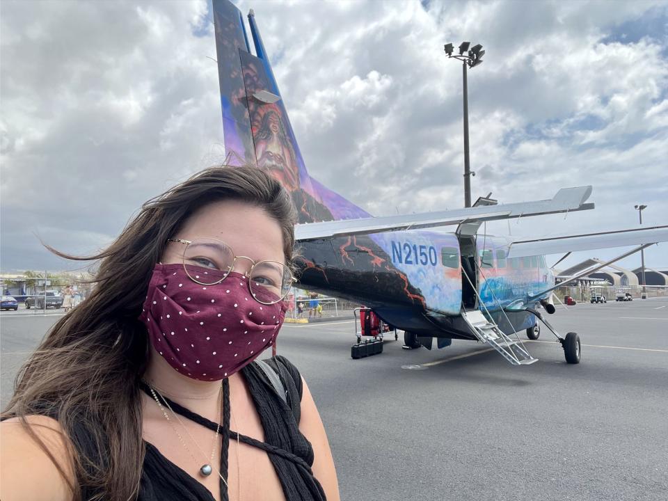 The writer wearing a mask and taking a selfie in front of a small plane