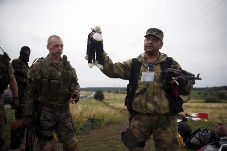 A pro-Russian separatist holds a stuffed toy found at the crash site of Malaysia Airlines flight MH17, near the settlement of Grabovo in the Donetsk region, July 18, 2014. REUTERS/Maxim Zmeyev