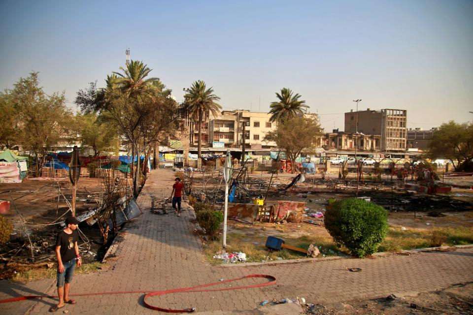 Protesters inspect burned tents near Tahrir Square, Baghdad, Iraq, Monday, July, 27, 2020. Fresh violence erupted between demonstrators and Iraqi security forces in central Baghdad, human rights monitors and Iraqi security and health officials said on Monday, following months of quiet in the wake of the coronavirus pandemic.(AP Photo/Khalid Mohammed)