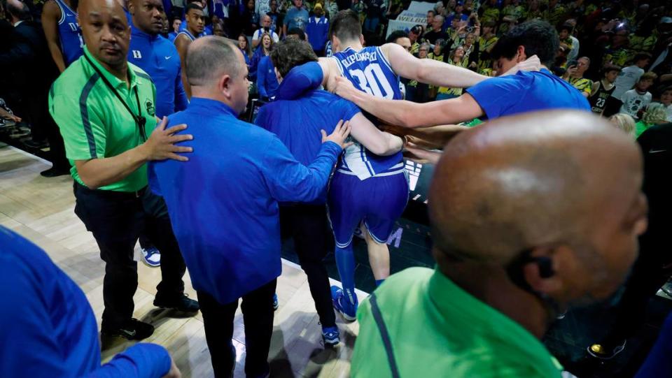 Duke’s Kyle Filipowski (30) is helped off the court after the Wake Forest fans rushed the court after Wake Forest’s 83-79 victory over Duke at Lawrence Joel Veterans Memorial Coliseum in Winston-Salem, N.C., Saturday, Feb. 24, 2024.