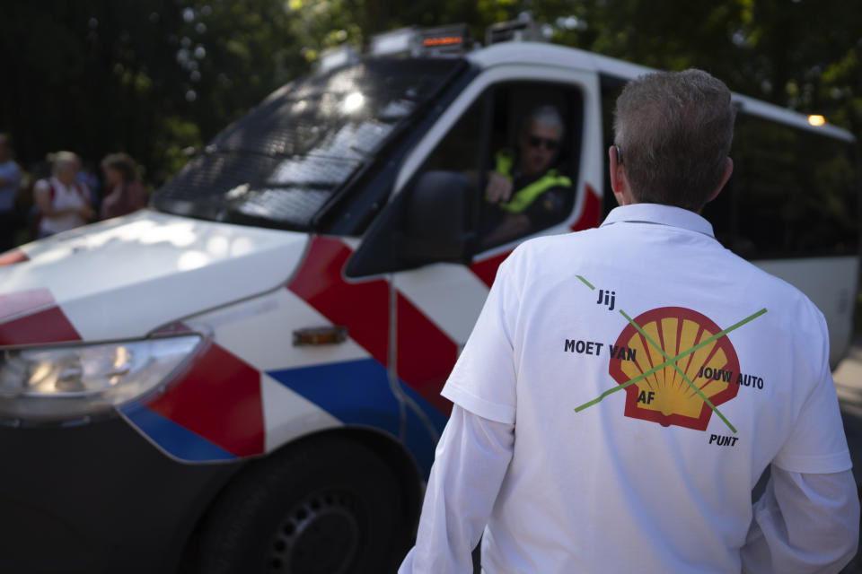 A protestor wears a shirt with the Shell logo and a text reading "get rid of your car, period" as people gathered with the intent to block a highway during a climate protest of Extinction Rebellion and other activists near the Dutch parliament in The Hague, Netherlands, Saturday, Sept. 9, 2023. (AP Photo/Peter Dejong)