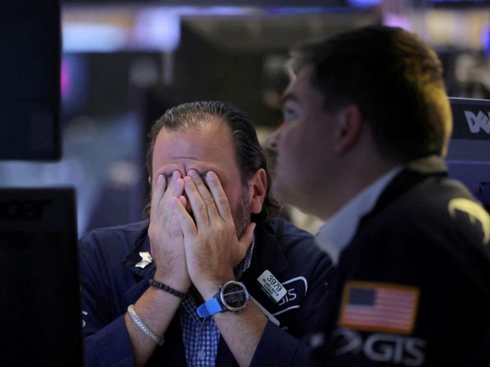 FILE PHOTO: Traders work on the trading floor at the New York Stock Exchange (NYSE) in Manhattan, New York City