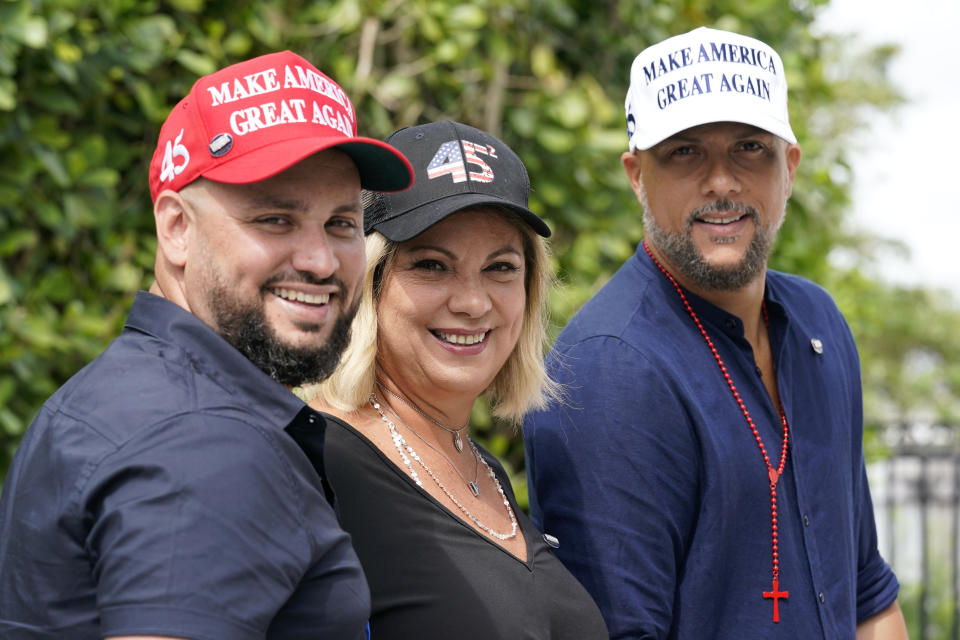 Tirso Luis, left, Ana Paez, and German Pinelli, right, members of the band Los 3 de la Habana, pose for a photograph, Thursday, Oct. 22, 2020, in Miami. The Cuban artists, who sought asylum in the U.S., have composed a salsa song in support of President Donald Trump, which is now being used as a full-fledged campaign ad. (AP Photo/Lynne Sladky)