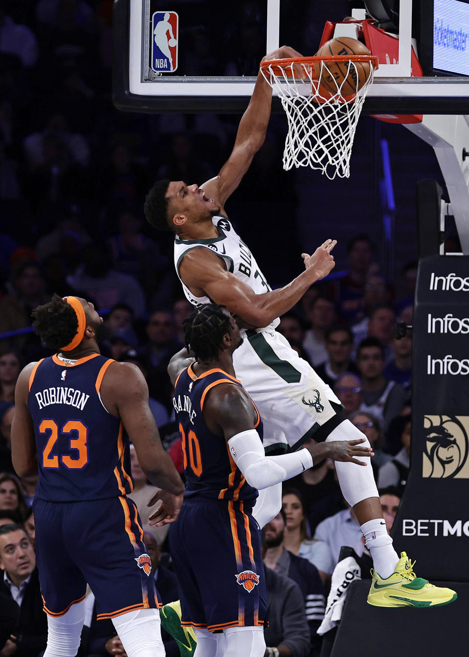 Milwaukee Bucks forward Giannis Antetokounmpo dunks over New York Knicks forward Julius Randle (30) during the first half of an NBA basketball game Wednesday, Nov. 30, 2022, in New York. (AP Photo/Adam Hunger)