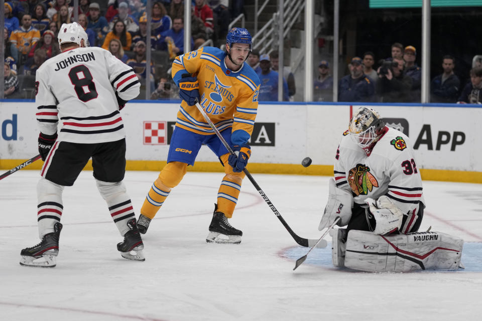 Chicago Blackhawks goaltender Alex Stalock (32) deflects a puck as St. Louis Blues' Logan Brown (22) and Blackhawks' Jack Johnson (8) watch during the second period of an NHL hockey game Thursday, Dec. 29, 2022, in St. Louis. (AP Photo/Jeff Roberson)