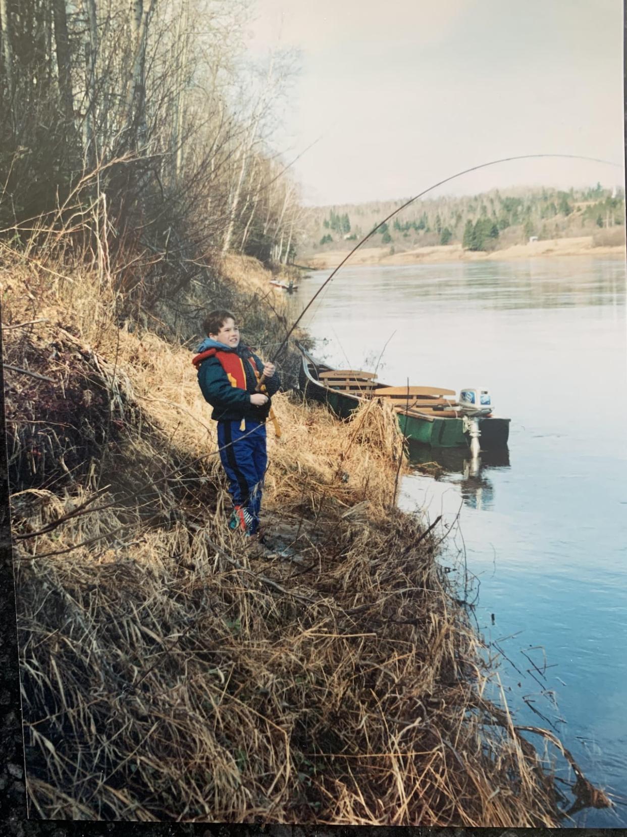 Young Nick Hawkins fighting a salmon on the Miramichi River. (Submitted by Nick Hawkins - image credit)
