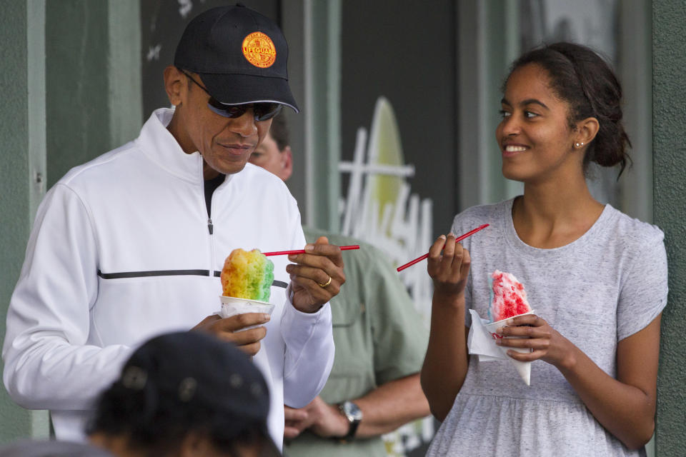 President Barack Obama eats shave ice with daughter Malia Obama at Island Snow, Thursday, Jan. 1, 2015, in Kailua, in Hawaii during the Obama family vacation.