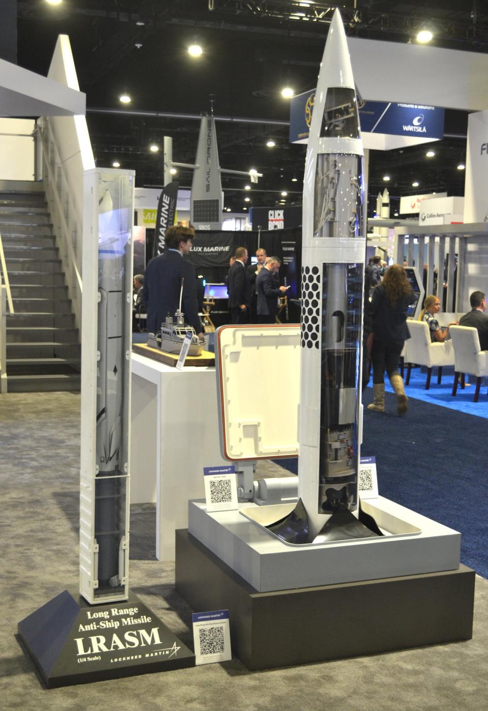 A 1/4 scale model of a canisterized variant of the AGM-158C Long Range Anti-Ship Missile (LRASM) for use with the Mk 41 VLS (at left) and one depicting a PAC-3 MSE surface-to-air missile being launched from a Mk 41 cell (at right). <em>Joseph Trevithick</em>