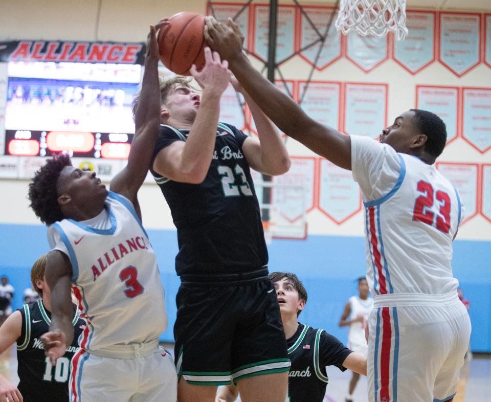 Diego Allen and Ramhir Hawkins of Alliance block a shot attempt by West Branch center Thomas Egli on Friday, Dec. 16, 2022