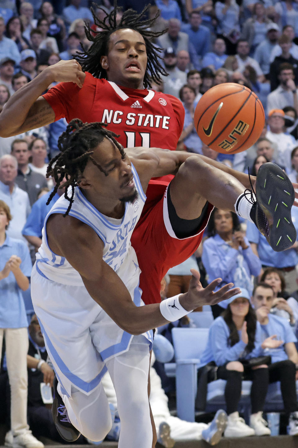 North Carolina State guard Dennis Parker Jr., top, and North Carolina forward Jae'Lyn Withers, bottom, battle for the ball during the second half of an NCAA college basketball game Saturday, March. 2, 2024, in Chapel Hill, N.C. (AP Photo/Chris Seward)