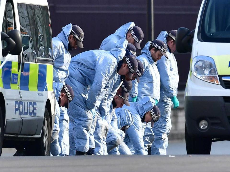 Police conduct a fingertip search near Parliament yesterday (PA)