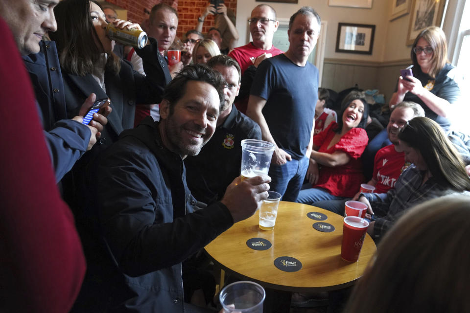 US actor Paul Rudd sits alongside Wrexham fans in The Turf Pub ahead of the National League soccer match between Wrexham and Boreham Wood at The Racecourse Ground, in Wrexham, Wales, Saturday April 22, 2023. (Martin Rickett/PA via AP)