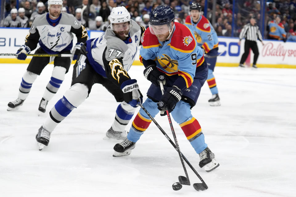 Florida Panthers center Sam Bennett (9) tries to work around Tampa Bay Lightning defenseman Victor Hedman (77) during the first period of an NHL hockey game Saturday, Dec. 10, 2022, in Tampa, Fla. (AP Photo/Chris O'Meara)