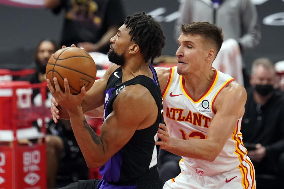 Toronto Raptors center Khem Birch (24) gets fouled by Atlanta Hawks guard Bogdan Bogdanovic (13) during the first half of an NBA basketball game Tuesday, April 13, 2021, in Tampa, Fla. (AP Photo/Chris O'Meara)