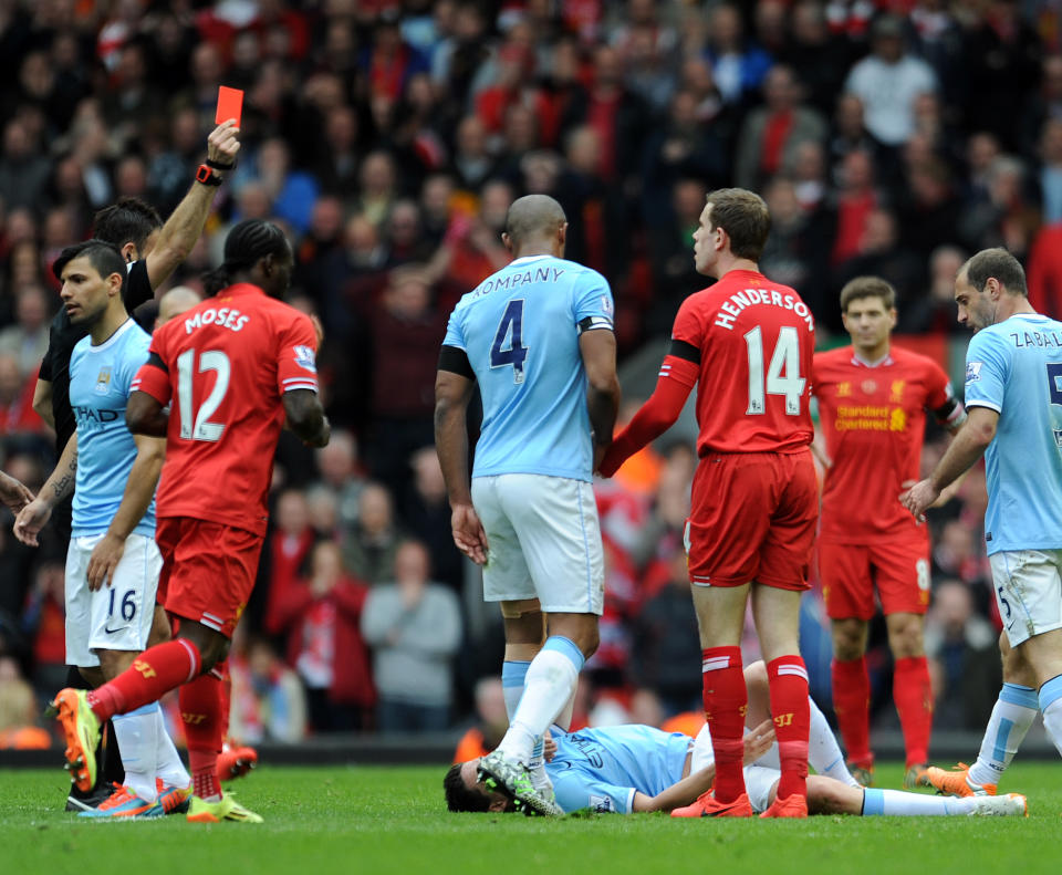 Liverpool's Jordan Henderson third right, is shown a red card by referee Mark Clattenburg left, after he fouls Manchester City's Samir Nasri during their English Premier League soccer match at Anfield in Liverpool, England, Sunday April. 13, 2014. (AP Photo/Clint Hughes)