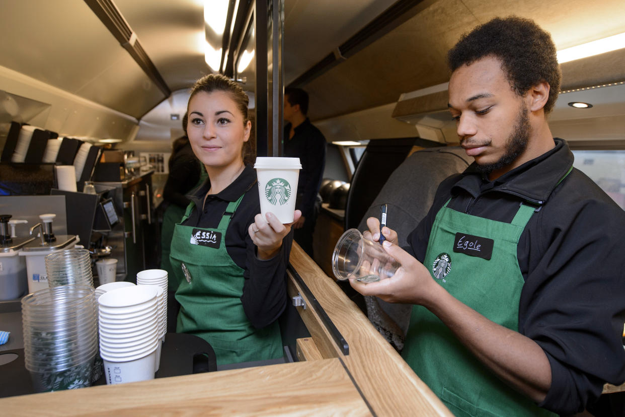 US coffee giant Starbucks employee Essia (L) and Egole prepare beverages in the world's first coffee house on a train on November 14, 2013, in Zurich. The two floor restaurant carriage transformed into a coffee house is part of a pilot project and the train will run twice daily between Geneva and St. Gallen from November 21 onwards. AFP PHOTO / FABRICE COFFRINI        (Photo credit should read FABRICE COFFRINI/AFP via Getty Images)
