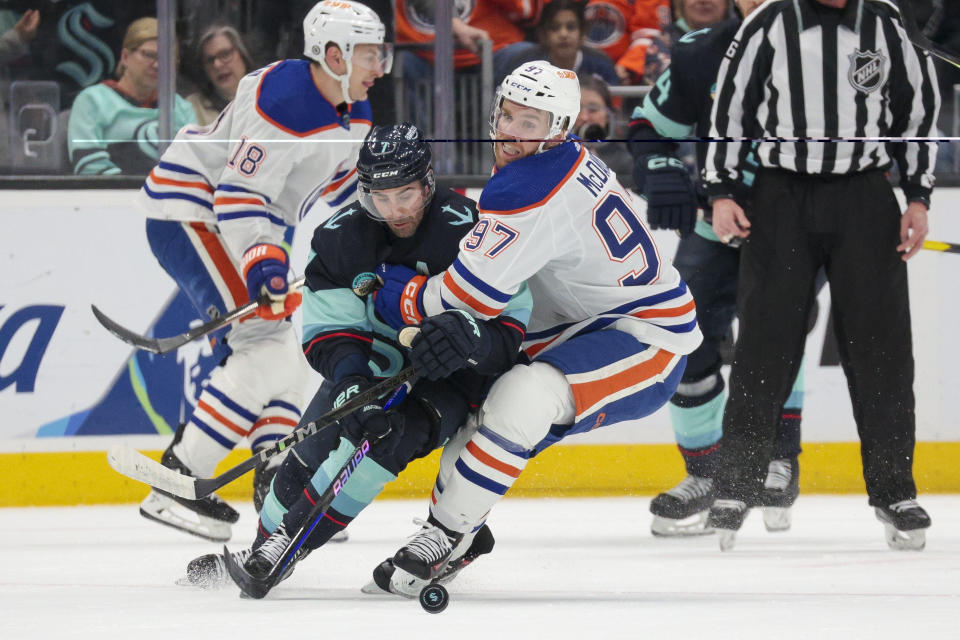 Edmonton Oilers center Connor McDavid (97) and Seattle Kraken right wing Jordan Eberle (7) go for the puck during the first period of an NHL hockey game Saturday, March 2, 2024, in Seattle. (AP Photo/Jason Redmond)