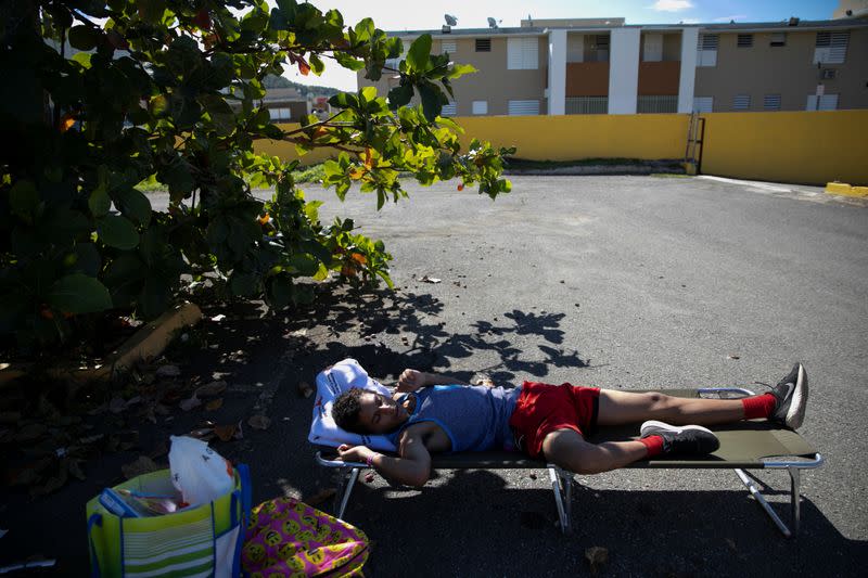 A boy sleeps in a camp bed at a temporary shelter camp in a sport complex, after an earthquake in Guanica