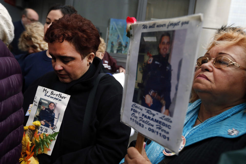 Iliana Flores, left, and her mother Ilia Rodriguez hold photos of Carlos Lillo, Iliana's brother and Ilia's son, as they join other family members of victims of the of the Sept. 11, 2001 attacks in protest of the transfer of unidentified remains of those killed at the World Trade Center from the Office of the Chief Medical Examiner to the World Trade Center site, Saturday, May 10, 2014, in New York. The remains will be transferred to an underground repository in the same building as the National September 11 Memorial Museum. (AP Photo/Jason DeCrow)