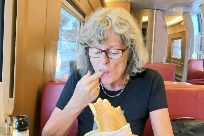 Person eating a sandwich on a train