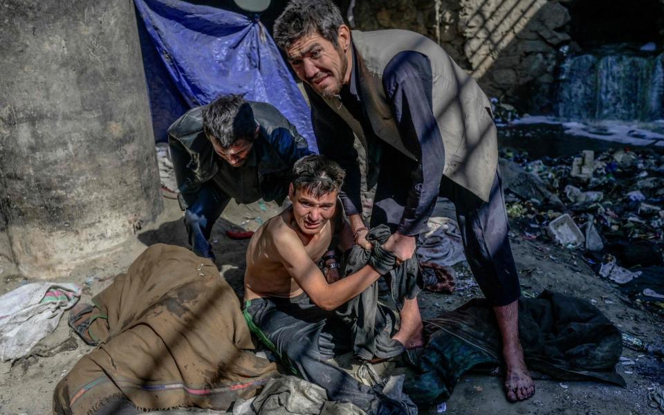 Drug treatment workers try to convince a man to go into the detoxification centre in Kabul - BULENT KILIC