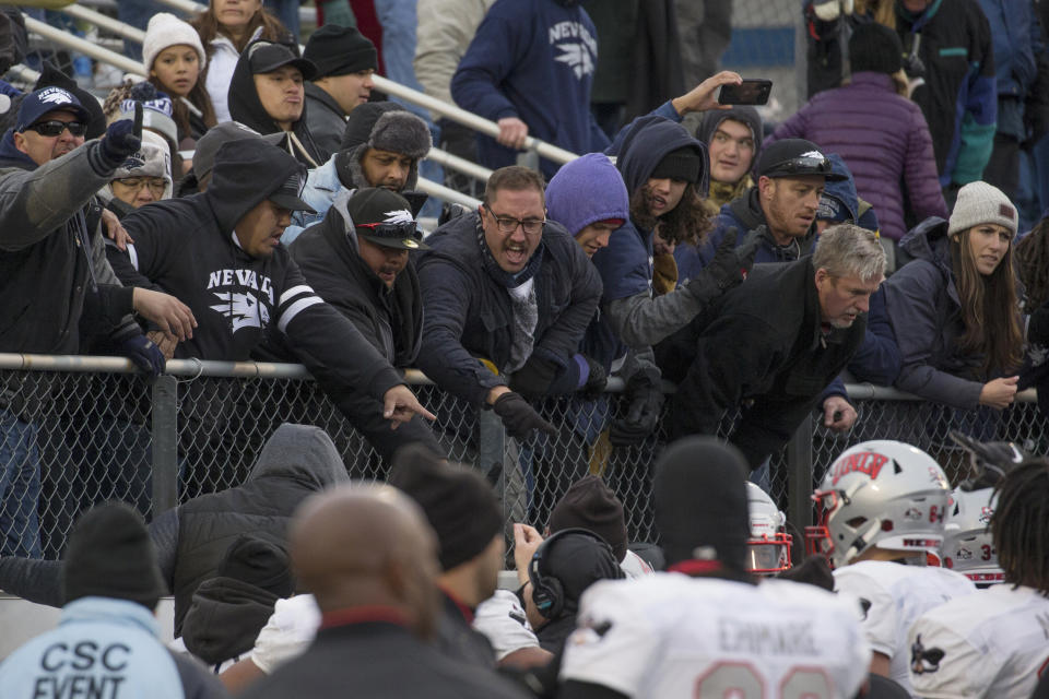 FILE - In this Nov. 30, 2019, file photo, fans shout at players during a post-game scuffle at the end of an NCAA college football game between UNLV and Nevada in Reno, Nev. The Las Vegas Raiders were the first team to play inside Allegiant Stadium. But the UNLV Rebels will be the first team to play with fans inside the $2 billion dollar venue, when they host in-state rival Nevada on Saturday, Oct. 31, 2020. (AP Photo/Tom R. Smedes)