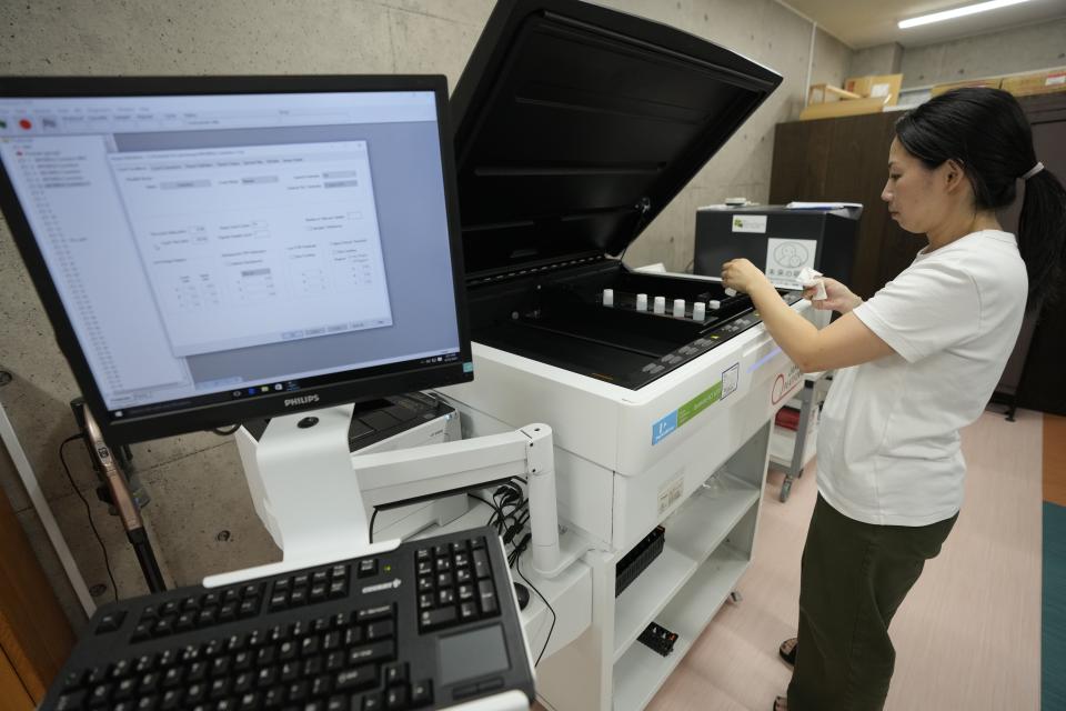 A staff of Mothers' Radiation Lab Fukushima, known as a citizens' testing center Tarachine, tests sample seawater taken near the Fukushima Daiichi nuclear power plant, damaged by a massive March 11, 2011, earthquake and tsunami, at the testing center, with a liquid scintillation analyzer in Iwaki, Fukushima prefecture, northeastern Japan on Friday, Aug. 25, 2023. The Fukushima Daiichi nuclear power plant started releasing treated and diluted radioactive wastewater into the Pacific Ocean on Thursday. (AP Photo/Eugene Hoshiko)