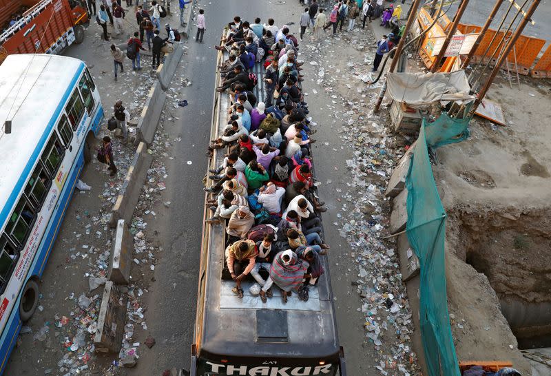 Trabajadores migrantes viajan en un autobús lleno de gente para regresar a sus aldeas, durante un bloqueo nacional de 21 días para limitar la propagación de la enfermedad por coronavirus (COVID-19), en Ghaziabad, en las afueras de Nueva Delhi, India.
