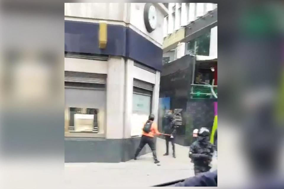 One suspect is seen striking the window of Mappin & Webb in Fenchurch Street with an axe