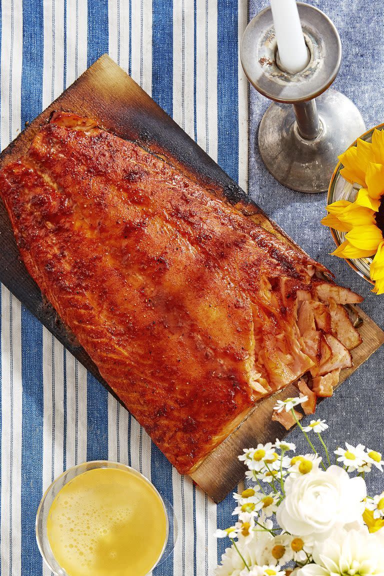 sweet and smoky cedar planked salmon on the plank with some salmon flaked off one end