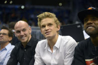 Singer Cody Simpson, second from right, watches an Orlando Magic game from his court-side seats during the first half of an NBA basketball game against the Toronto Raptors in Orlando, Fla., Thursday, Jan. 24, 2013. Simpson was dominating attention ahead of Australia’s Olympic swimming trials, until Maddie Groves pulled out of the six-day meet following a series of social media posts condemning “misogynistic perverts” in the sport.(AP Photo/Phelan M. Ebenhack)