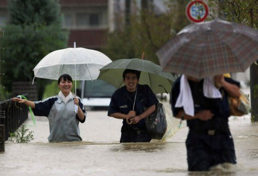 Evacuees walk through floodwaters in Nagoya, Aichi prefecture, in central Japan. More than a million people in Japan were warned to leave their homes on Tuesday as an approaching typhoon brought heavy rain and floods which left three dead or missing