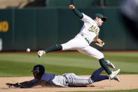 Seattle Mariners' Dylan Moore, bottom, steals second base under Oakland Athletics shortstop Nick Allen, who cannot catch the ball on a throwing error by catcher Shea Langeliers, during the eighth inning of a baseball game in Oakland, Calif., Thursday, Sept. 22, 2022. Moore advanced to third base on the play. (AP Photo/Jeff Chiu)