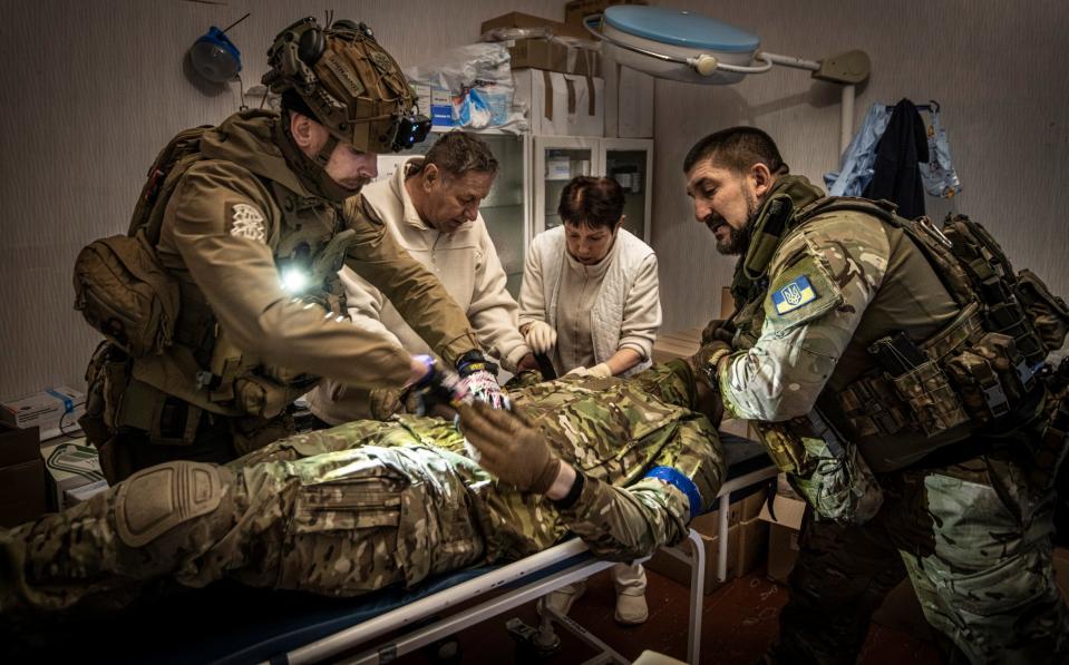An infantryman being treated after being shot in the upper arm