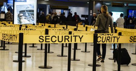 Passengers make their way in a security checkpoint at the International JFK airport in New York October 11, 2014. REUTERS/Eduardo Munoz