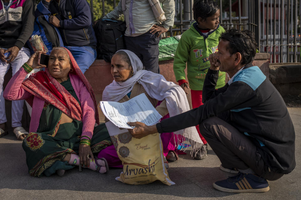 Patients and their attendants squat outside the All India Institute of Medical Sciences (AIIMS) hospital in New Delhi, India, Wednesday, Dec. 7, 2022. The leading medical institute in India's capital limped back to normality on Wednesday after a cyberattack crippled its operations for nearly two weeks. (AP Photo/Altaf Qadri)