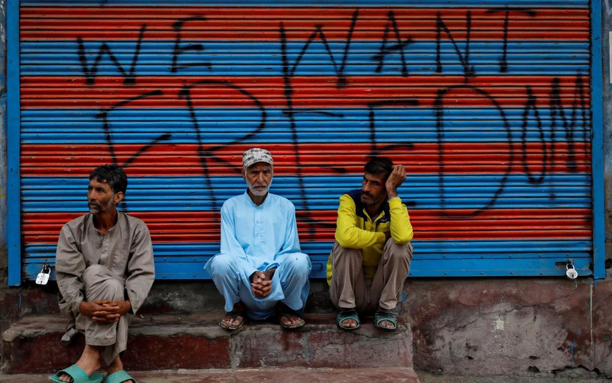 Kashmiri men wait before Eid-al-Adha prayers in Srinagar - REUTERS