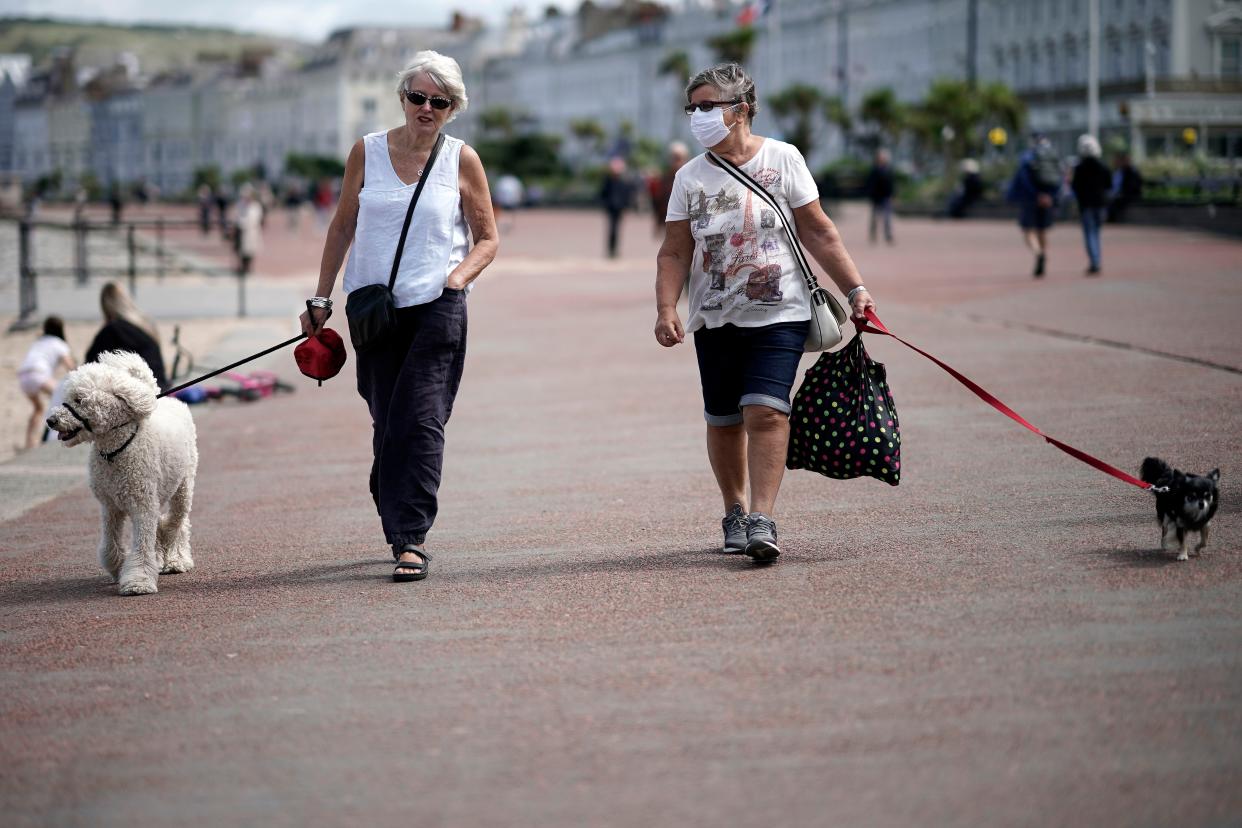 People relax and enjoy Llandudno promenade after pandemic travel restrictions were eased on July 6, 2020, in Llandudno, United Kingdom. Lockdown restrictions continue to be eased in Wales as the number of coronavirus cases continues to fall. The "stay local" guidance has been dropped and people are now allowed to travel further than five miles from their home. Outdoor attractions have been allowed to open and two households can stay together indoors and overnight. The Welsh assembly is hoping to open self-contained holiday accommodation from July 11 giving a welcome boost to the tourist industry.