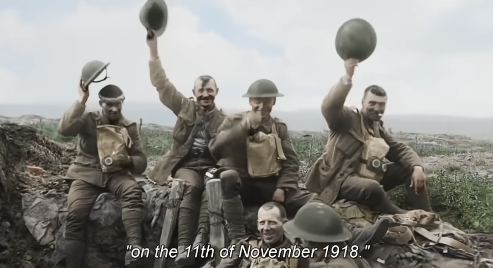 Five soldiers celebrating, waving hats, caption reads "on the 11th of November 1918."